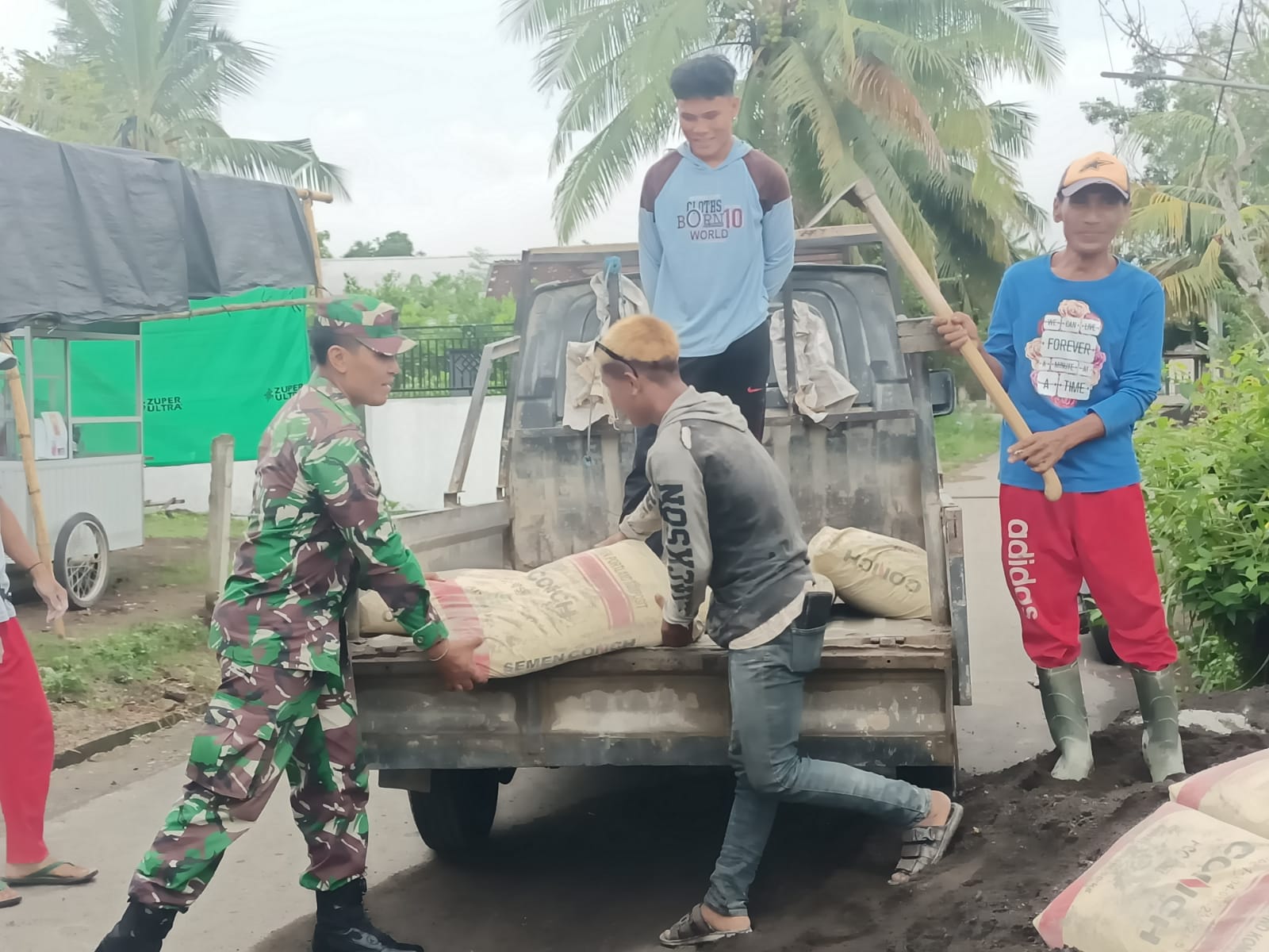 Wujud Kemanunggalan TNI-Rakyat, Babinsa Seteluk Rea Gotong Royong Angkut Material Bangunan