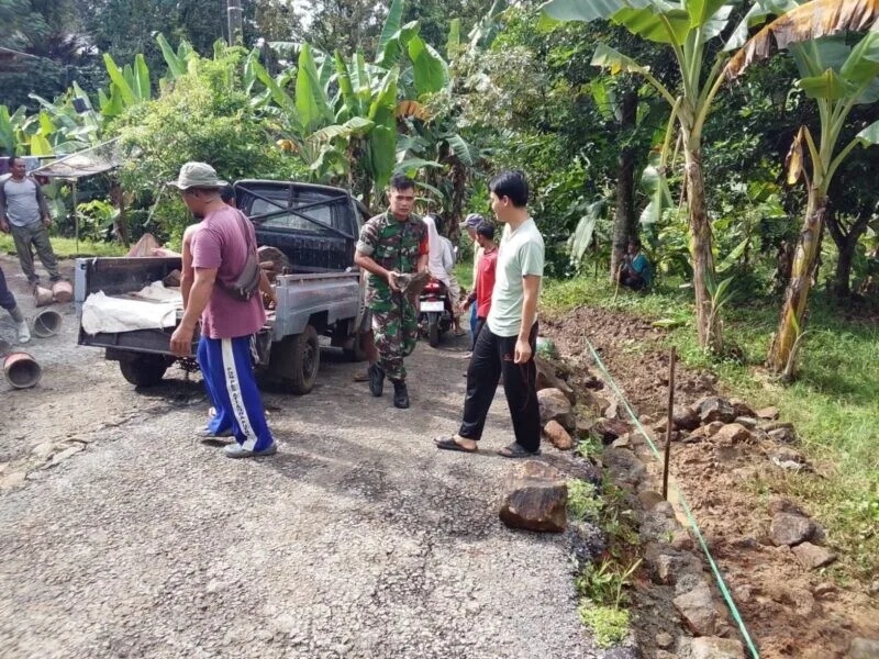 Babinsa Koramil 2201/Cisolok Laksanakan Karya Bakti Pembersihan Jalan Bersama Warga