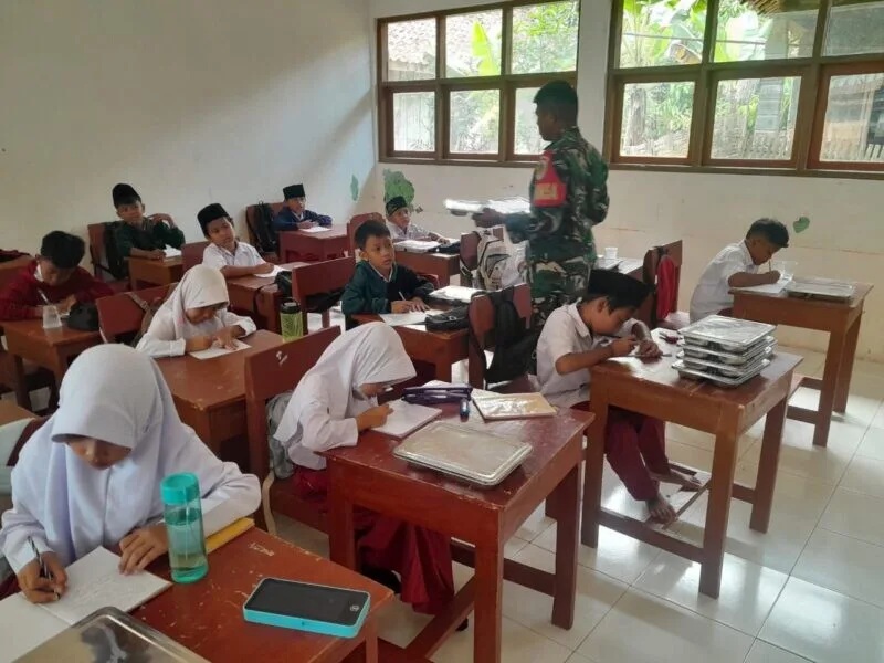 Babinsa Koramil 2212/Tegalbuleud Dampingi Penyaluran Makan Bergizi Gratis Bagi Anak Sekolah Di Desa Sirnamekar