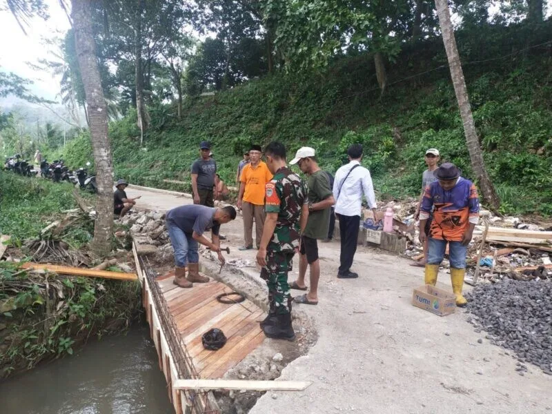 Babinsa Koramil 2202/Palabuhanratu Gotong Royong Pelebaran Jembatan Bersama Warga Di Desa Tonjong