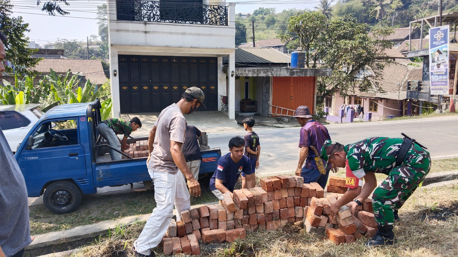 Babinsa Koramil 2208/Nyalindung Bersama Warga Laksanakan Karya Bakti Pemasangan Bata Merah Lapangan Voli