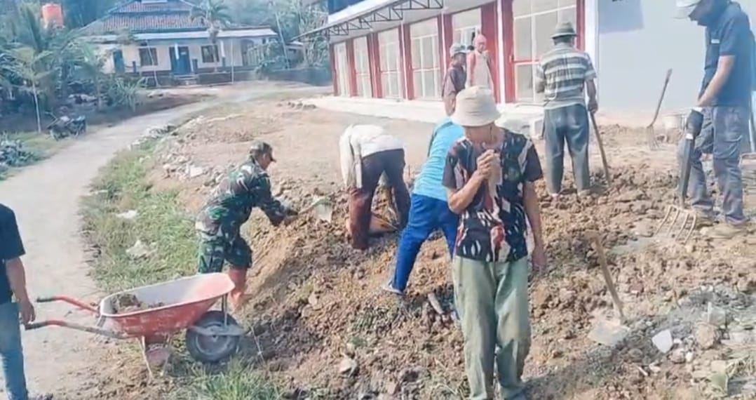 Babinsa Koramil 2209/Lengkong Bersama Warga Laksanakan Karya Bakti Bersihkan Halaman Kopdes Langkapjaya