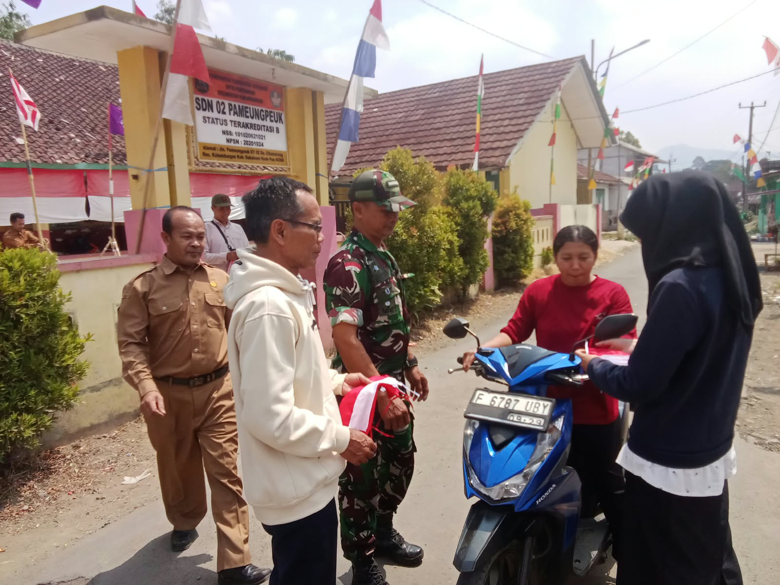 Sambut HUT Ke-81 RI, Babinsa dan Perangkat Desa Cihamerang Bagikan Bendera Merah Putih kepada Warga