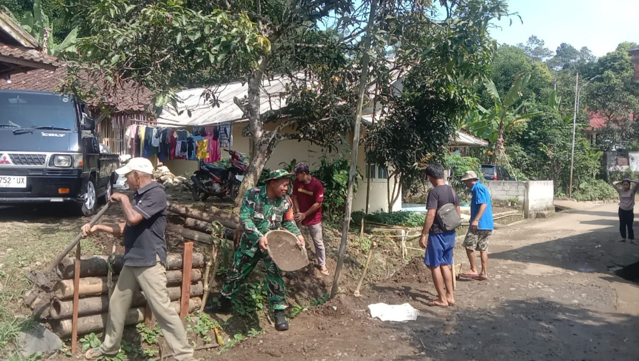 Babinsa Koramil 2204/Cikidang Laksanakan Bhakti Pelebaran Jalan Desa Cikidang