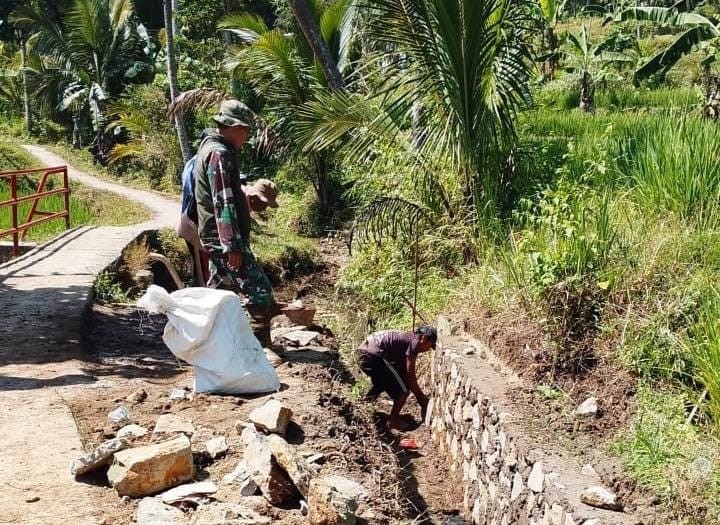 Babinsa Tanjungsari Bersama Masyarakat Laksanakan Karya Bakti Perbaikan Irigasi Sawah