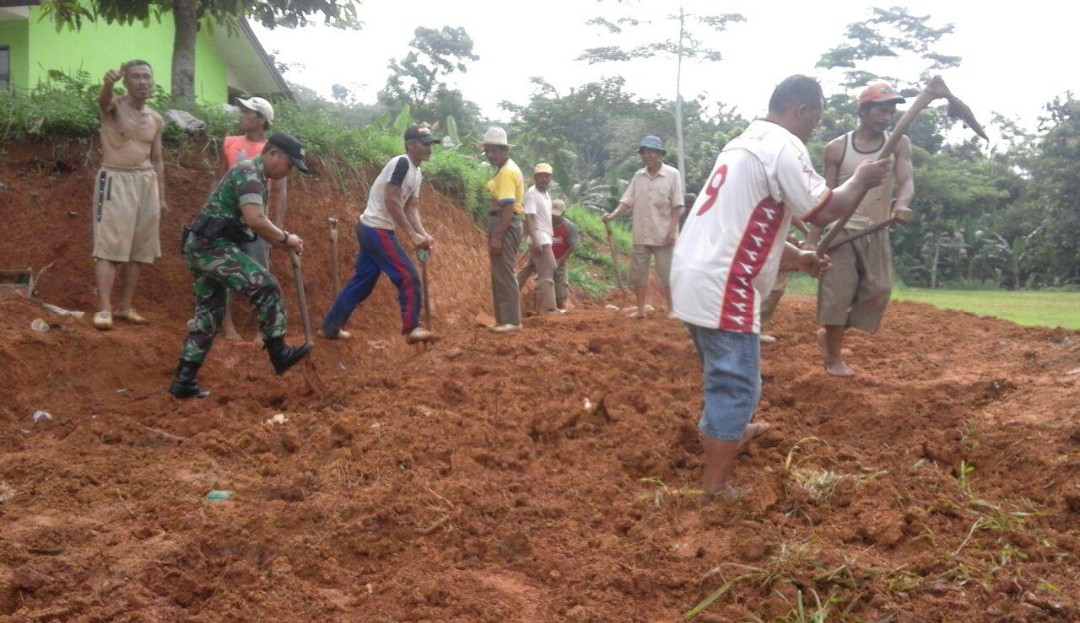 Babinsa Tanjungsari Laksanakan Karya Bakti Perbaikan Jalan Bersama Warga