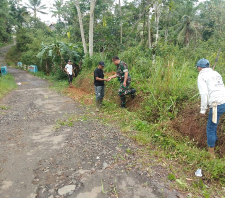 Babinsa Desa Cidadap Laksanakan Karya Bakti Bersihkan Selokan Jalan