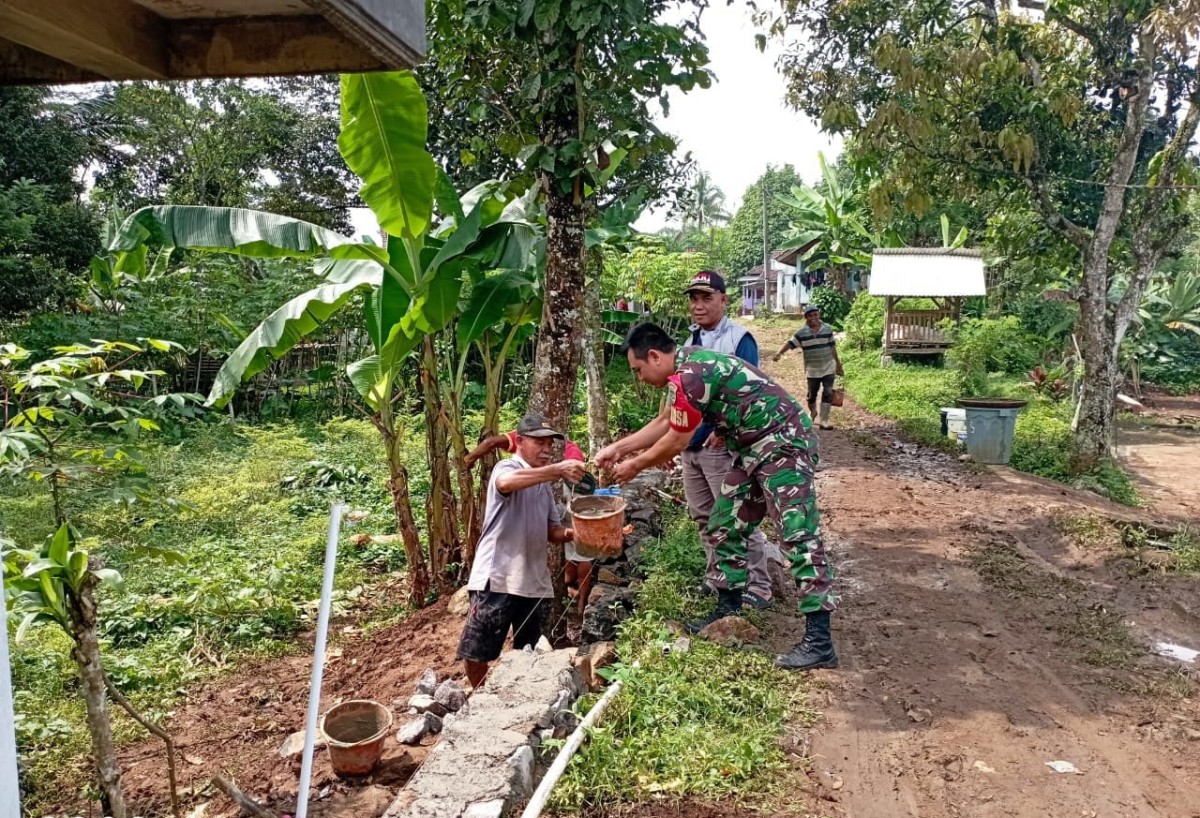Babinsa Koramil 2206/Parakan Salak Laksanakan Karya Bakti Pemasangan TPT Jalan di Desa Sukatani