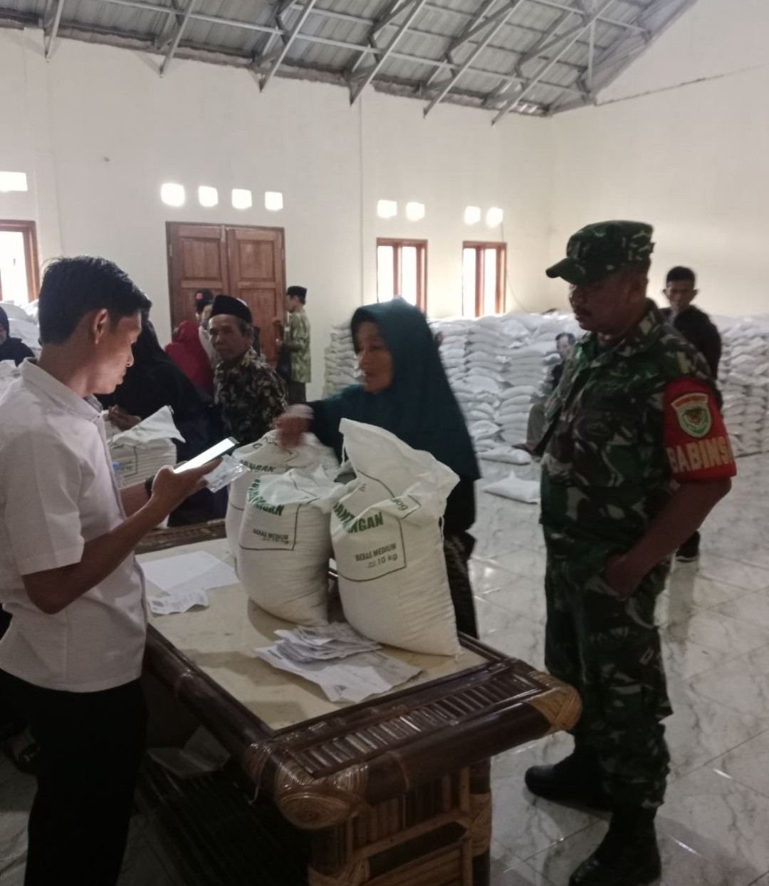 Babinsa Puncak Manggis Dampingi Pendistribusian Beras kepada Warga