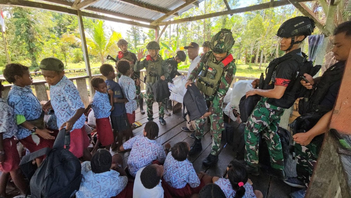 SATGAS YONIF 733/MASARIKU PERINGATI HARI ANAK NASIONAL DENGAN MEMBAGIKAN PAKET TAS SEKOLAH DAN MAKAN BERGIZI DI SD RIMBA SANTO ALOYSIUS MUMUGU