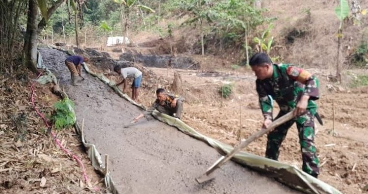Wujudkan Akses Jalan Layak, Babinsa Cijedil Turun Langsung Karya Bakti Pengerasan Jalan Bersama Warga